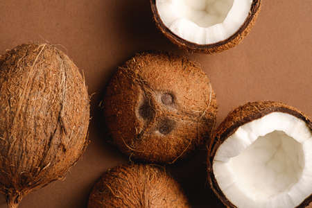 Coconut fruits on brown plain background, abstract food tropical concept, top viewの写真素材