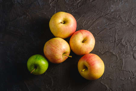 Fresh sweet apples on dark black textured background, top viewの写真素材
