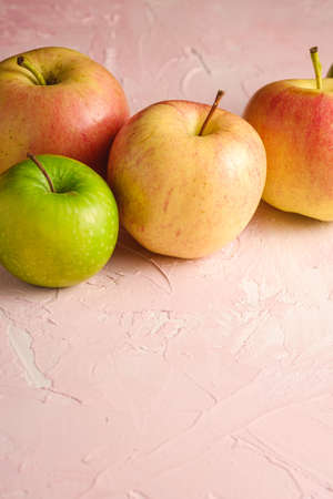 Fresh sweet apples on pink textured background, angle view copy spaceの写真素材
