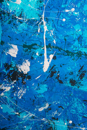 Photo of creative textured background in blue, black and white grunge colors, paint and splash drops backdropの写真素材