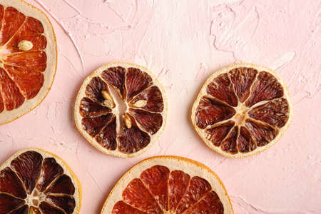Dried lemon and grapefruit slices, citrus fruits on pink textured background, top viewの写真素材