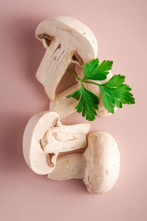 Sliced champignon mushrooms healthy food on pink plate with parsley greenery, top view macroの写真素材