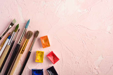 Paint brushes, artist tools for drawing on textured pink background, top view, copy spaceの写真素材