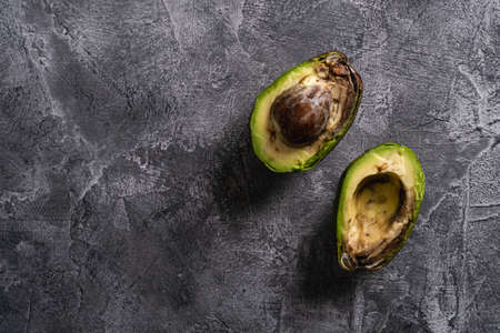 Rotten avocado, half sliced fruit, freegan food concept, grey background, top view copy spaceの写真素材