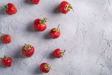 Fresh ripe strawberry fruits, summer vitamin berries on grey stone background, top view copy spaceの写真素材