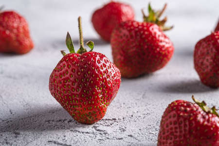 Fresh ripe strawberry fruits, summer vitamin berries on grey stone background, angle view macroの写真素材