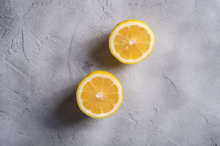 Two lemon slices, tropical citrus fruits on grey concrete background, top viewの写真素材