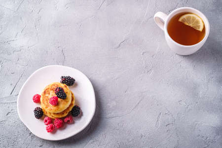 Cottage cheese pancakes, curd fritters dessert with raspberry and blackberry berries in plate near...