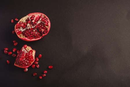 Fresh tasty sweet peeled pomegranate with red seeds on dark backgroundの写真素材