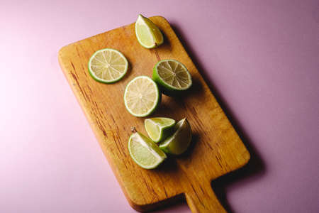 Fresh tasty lemon and lime citrus fruits slices on pink backgroundの写真素材