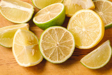 Fresh tasty lemon and lime citrus fruits slices on pink backgroundの写真素材