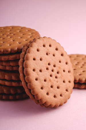 Chocolate sandwich cookie with cream on pink backgroundの写真素材