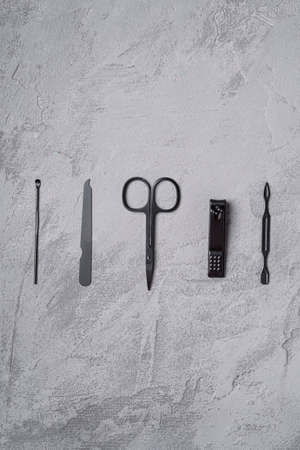 Set of manicure, pedicure tools and accessories in row, stone concrete background, top viewの写真素材