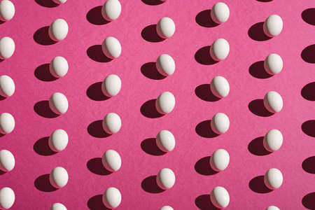 White eggs pattern on pink purple colors plain minimal background, angle view, happy Easter day