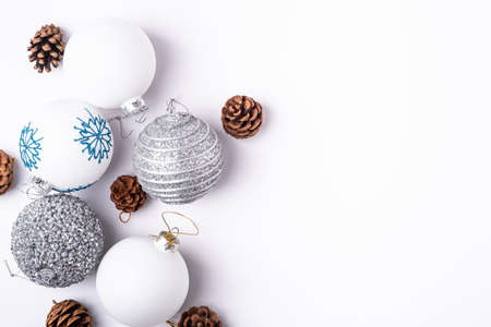 Christmas New Year composition. Gifts, fir tree cones, silver ball decorations on white background. Winter holidays concept. Flat lay, top view, copy spaceの写真素材