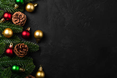 Christmas composition. Colorful ornament, pine cones and fir needles decorations on dark background....