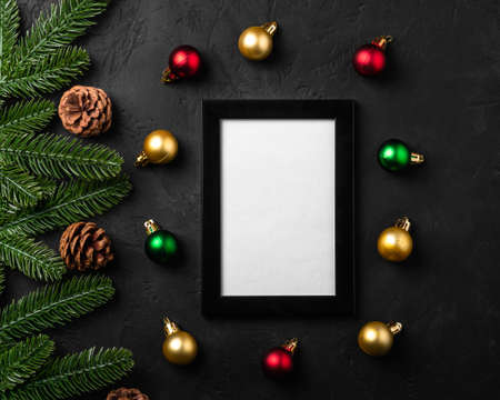 Christmas composition with empty picture frame. Colorful ornament, pine cones and fir needles...