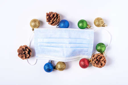 Christmas composition with medical face mask and colorful balls, ornaments decorations on white backgroundの写真素材