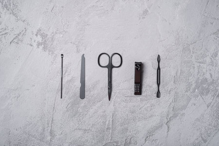 Set of manicure, pedicure tools and accessories in row, stone concrete background, top viewの写真素材