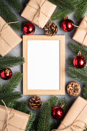 Christmas holidays composition with picture frame mockup. Red baubles, gifts and fir-tree branches.の写真素材