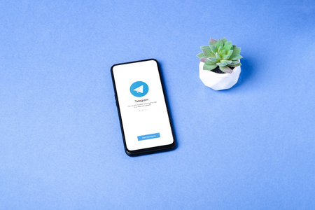 Melitopol, Ukraine - January 18 2021: Telegram application icon on smartphone screen. Online secure social media network. Blue backgroundのeditorial素材