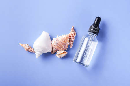 Skin care essence oil dropper in glass bottle on blue backgroundの写真素材