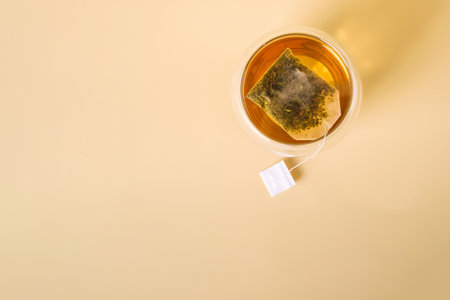 Hot green tea in double walled glass cup with tea bag, top viewの写真素材