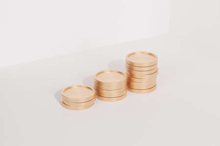 Golden coin stacks growing graph on white background, business investment and saving money concept, realistic 3d renderの写真素材