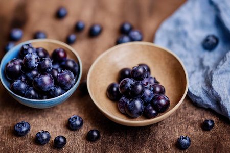 Bowl of fresh blueberries on blue rustic wooden table closeup.の写真素材