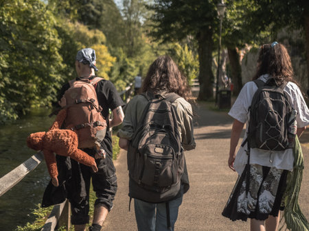 Group of people walking by the road in beautiful sunlight. Close up Back viewの写真素材