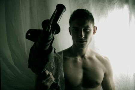 strong brawny guy with an electrodrill in a hand. Photo.の写真素材
