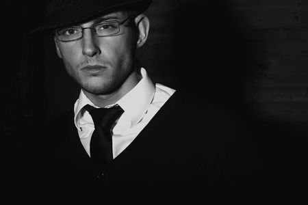 Portrait of young stylish man with serious face in black hat. Black-white photo.の写真素材