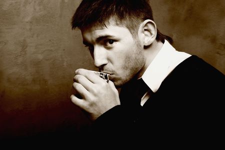 Beautiful young boy sipping coffee latte. Cepia photo.
