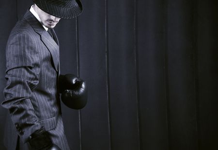 Gangster in grey suit in boxing gloves on his hands. Photo with copyspace.の写真素材
