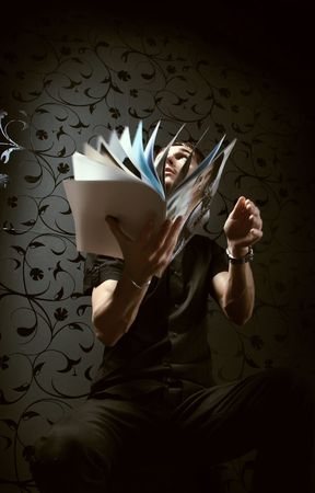 man in black thumbs through fashionable magazine. Photo.
