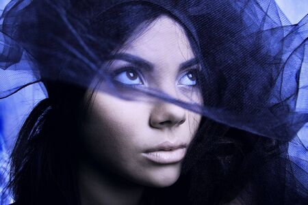 East woman peeking out from behind veil. Photo.の写真素材