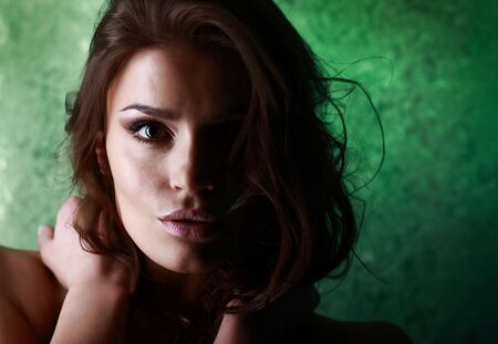 Young attractive brunette Caucasian woman on green background. の写真素材