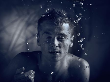 glamour portrait of the man on jets of waterの写真素材