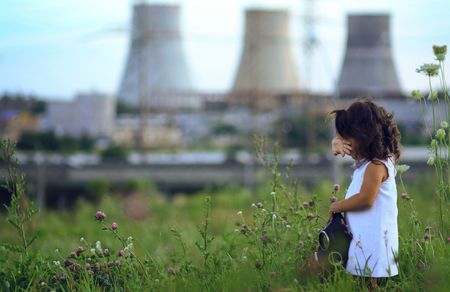Little girl against power station.の写真素材