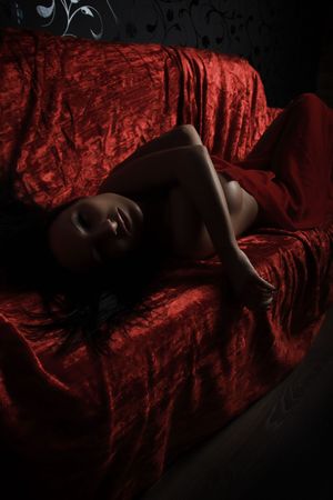 very sexy woman covered with red silk sheetの写真素材