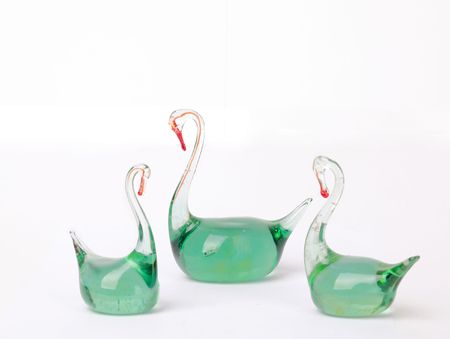 Glass green figures of swans isolated on a white backgroundの写真素材