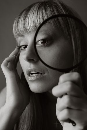 Attractive young girl looking through magnifierの写真素材