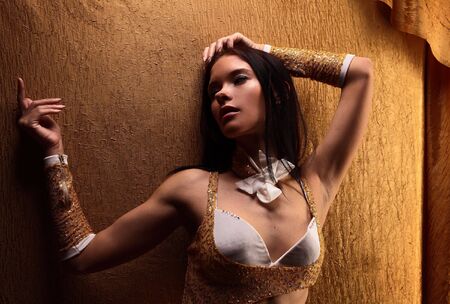 Young attractive girl on gold backgroundの写真素材