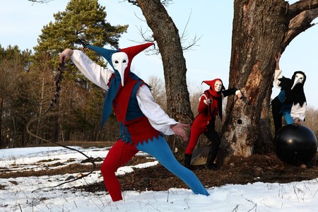 Troupe of medieval actors in suits of ancient clowns entertaining people.の写真素材