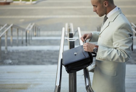 Business man holding elegant black leather briefcase.の写真素材