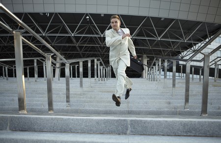 Jumping businessman over urban backgroundの写真素材
