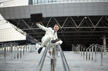 young businessman with briefcase running on stairの写真素材