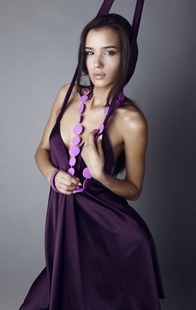 Sexy brunette posing in silk violet dress.の写真素材