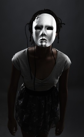 gloomy woman in silver mask posing on a black background.の写真素材