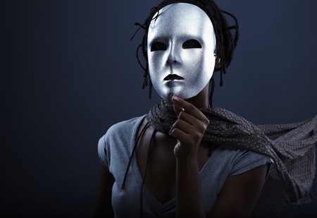 gloomy woman in silver mask posing on a black background.の写真素材